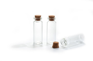 .Small glass bottles with cork lid on white background