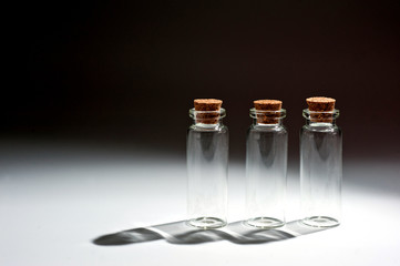 ..Small glass bottles with cork lid on a dark background