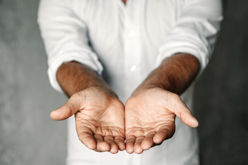 Close up of man's cupped hands show something on white background. Palms up. High resolution product - Powered by Adobe