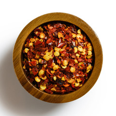 A pile of coarsely ground chilli peppers isolated on white from above.