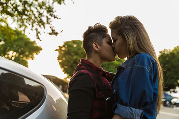 Fototapeta na wymiar Lesbian Couple Kissing in Car - Sunset Time