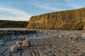 The stones and cliffs of Llantwit Major Beach in the evening sun, South Glamorgan, Wales, UK