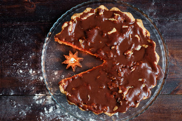 charlotte with chocolate glaze on wooden table with burning candle