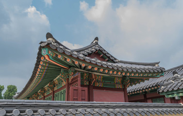 Naklejka premium Colorful architecture, wooden roof and tile details, and modeled blue sky, at Gyeongbokgung Palace, Seoul, South Korea