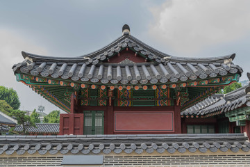 A fancy tiled rooftop, colorful architectural elements and a partial tile wall, at Gyeongbokgung...