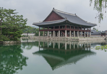 Fototapeta na wymiar Small decorative palace, surrounded by water, and a reflection of the palace on the water, in Gyeongbokgung Palace, Seoul, South Korea