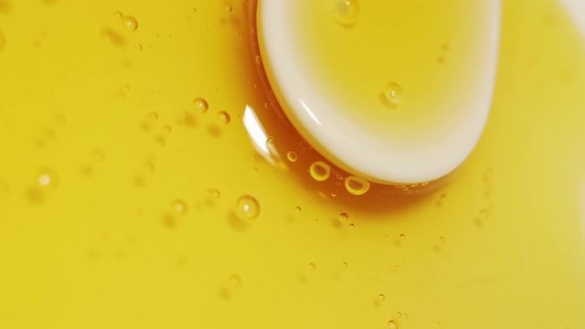 Honey on a ceramic white plate with spoon. Smoth rotation.