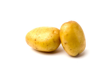 Two potatoes on a white background close-up. Two raw and washed potatoes on a white background