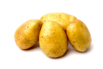 A lot of potatoes lie on a white background. A pile of washed and raw potatoes on a white background.