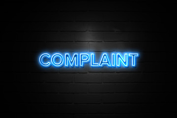 Complaint neon Sign on brickwall