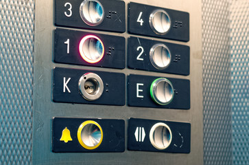 Aufzug Schaltknöpfe mit gelbem Hilfeknopf und Nummerierung vom Erdgeschoss bis zum 3. Stockwerk