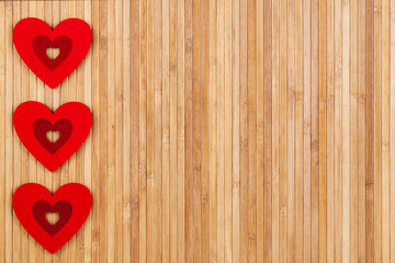 Three red Hearts on a wooden background, a card fort Valentine's day.