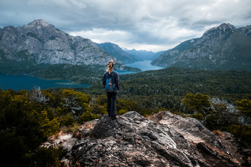 Woman hiker stands and enjoys valley view from the viewpoint. Patagonia, Argentina