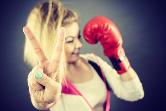 Woman wearing boxing gloves showing peace