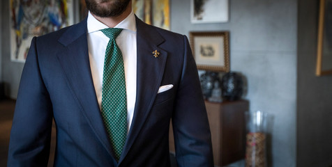 Attractive man in tailored suit standing and posing