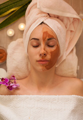 Beautiful woman with a clay or a mud mask on her face. pink clay. copy space. beauty salon