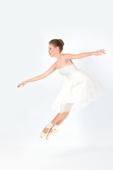 the ballerina in pointes and a white dress dances on a white background