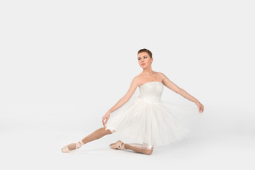Fototapeta na wymiar the ballerina in pointes and a white dress dances on a white background