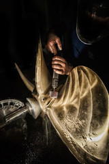 Heavy industry worker whit grinder boat propeller