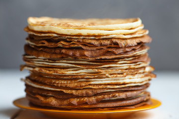 High stack of classic Russian thin pancakes. Rustic style. Traditional for the Russian pancake week Maslenitsa