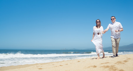 Young romantic couple walking on the beach