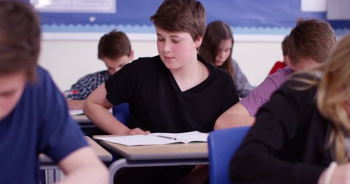 4k, School boy using the internet to cheat on his exam. Slow motion.