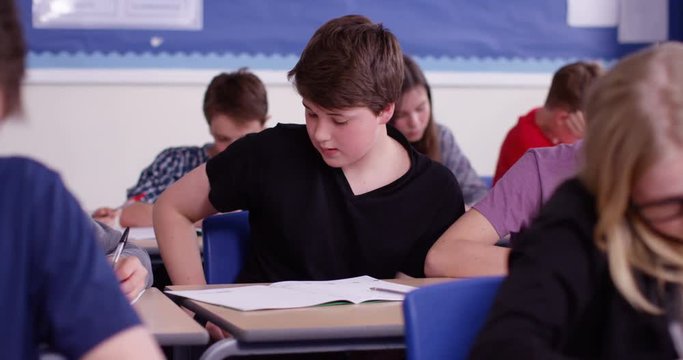 4k, School boy caught cheating using internet during his exam. Slow motion.