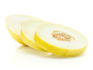 Yellow honeydew melon slices three rings with seeds isolated on white background.