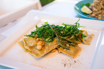 Ravioli with ricotta cheese, rucola and hazelnuts in italian restaurant