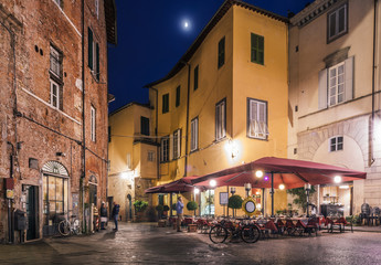 Fototapeta na wymiar Cafe in Piazza degli Scalpellini at night, Lucca, Italy