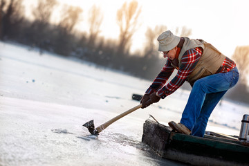 fisherman drill hole for winter fishing on the frozen lake