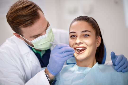 Dentist checking up female’s teeth