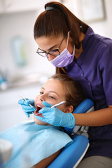 Female dentist repairing child's tooth