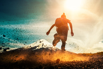 Woman athlete runs on a dirty and dusty ground with volcano on the background. Trail running...