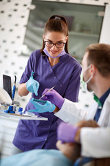 Dentist with female assistant working in dental ordination