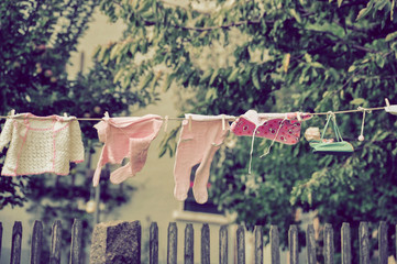 baby clothes hanging in garden on a clothesline