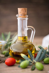 healthy olive oil and olive branch on the wooden table.