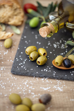 Olive oil and mix healthy olive on the wooden table .