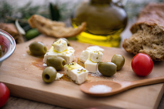 Greek cheese feta with virgin olive oil, green olives and fresh vegetables.