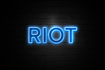 Riot neon Sign on brickwall