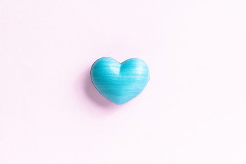 Blue heart shape over light color table. Concept of love, romance, and passion.