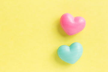 Couple of heart shapes over yellow table. Valentines day symbol for background use. Love, romance, and passion.