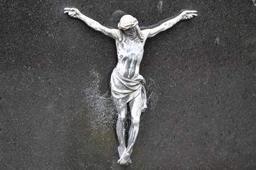 Tombstone sculpture of Jesus Christ covered by a spider web