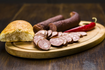 Homemade smoked sausage sliced on wooden board