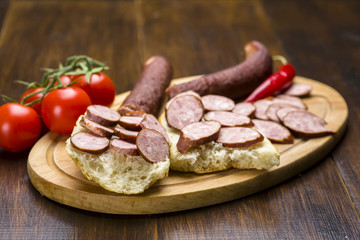 Sandwiches with homemade smoked sausage located on a board - food for consolation - tasty and healthy