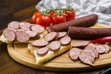 Sandwiches with homemade smoked sausage located on a board - food for consolation - tasty and healthy