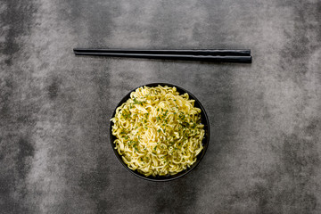 noodles in a bowl with broth and chopsticks