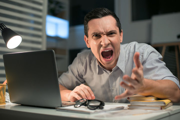 Fototapeta premium Leave me alone. Angry aggressive male employee stretching hand while roaring and staring at the camera