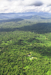 Obraz premium An aerial view of the Cockscomb Basin in central Belize, and some very remote houses nestled in the jungle.