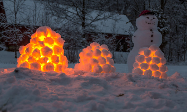 T&auml;nda sn&ouml;lyktor och en sn&ouml;gubbe en vinterkv&auml;ll